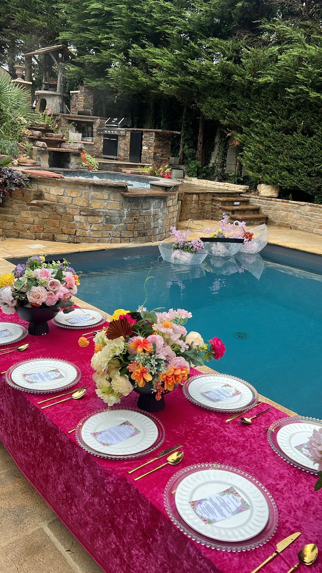 Table de fête aux tons fuchsia au bord de la piscine