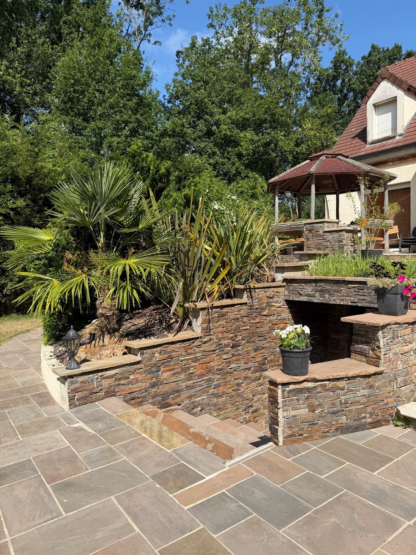 Les terrasses en pierre et le jardin luxuriant
