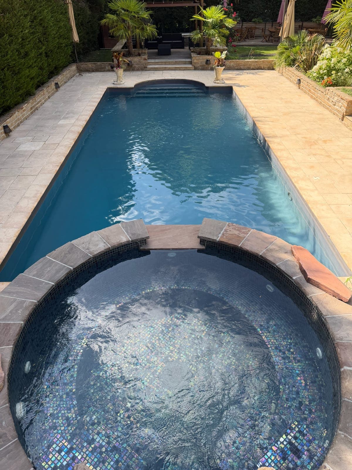 Le jacuzzi en pierre et la grande piscine creusée